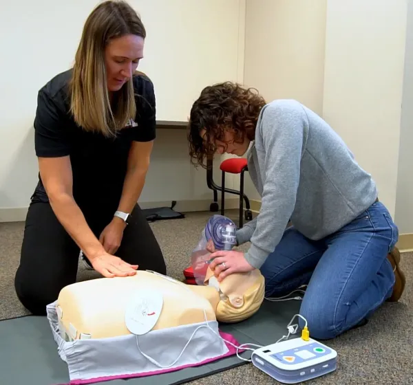 An Idaho Medical Academy Instructor observes as an AHA/CPR student performs basic airway management on a training mannequin.